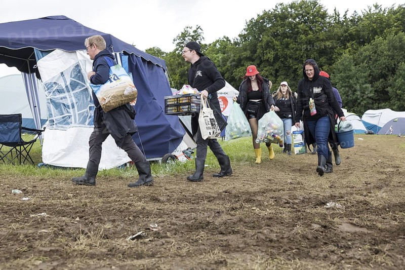 Festival visitors carry their luggage through mud on a campsite at the Rock am Ring festival on Saturday, Nürburgring race track race track, 07.06.2025
