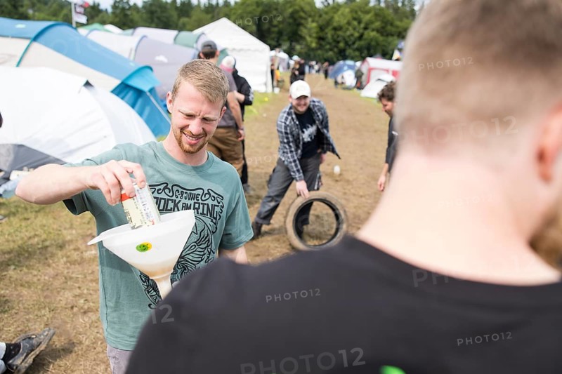 Festival visitors drinking from a funnel on a campsite at the Rock am Ring Festival on Saturday, Nürburgring race track race track, 07.06.2025
