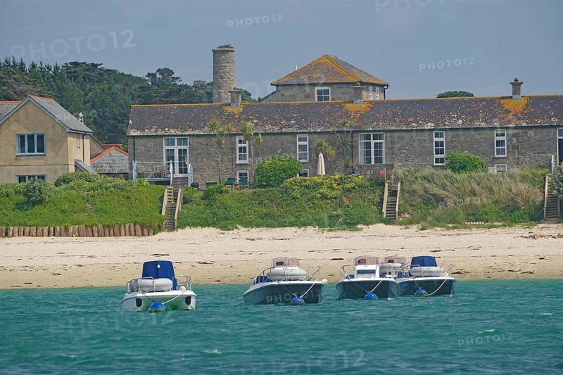 Four small boats close to the beach in front of traditional houses in an idyllic setting, Tresco, Isles of Scilly, Cornwall, England, United Kingdom