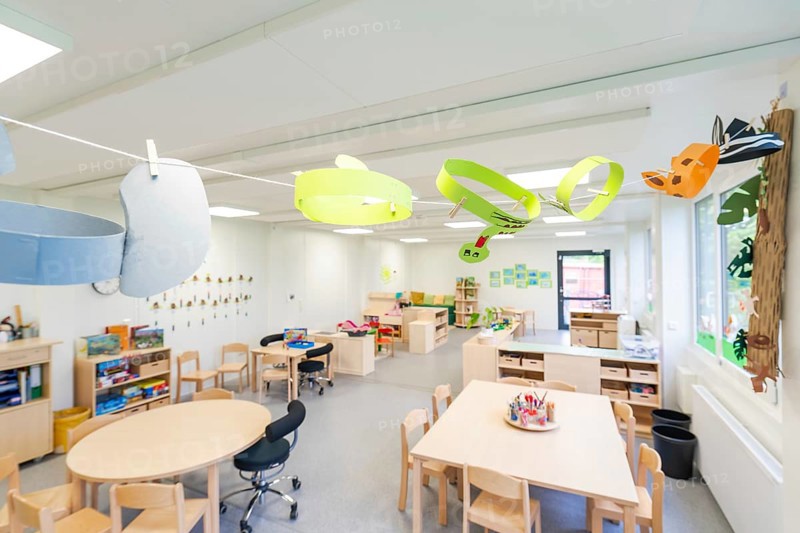 Creatively designed learning space with colourful paper decorations and wooden furniture, transitional daycare centre in container construction, Gechingen daycare centre, Calw district, Germany