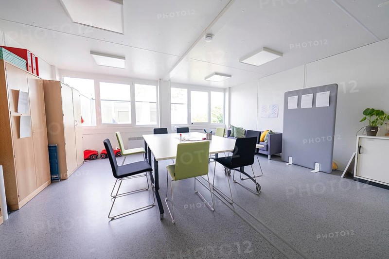 Modern meeting room with chairs around a table, large windows create light, transitional daycare centre in container design, Gechingen daycare centre, Calw district, Germany