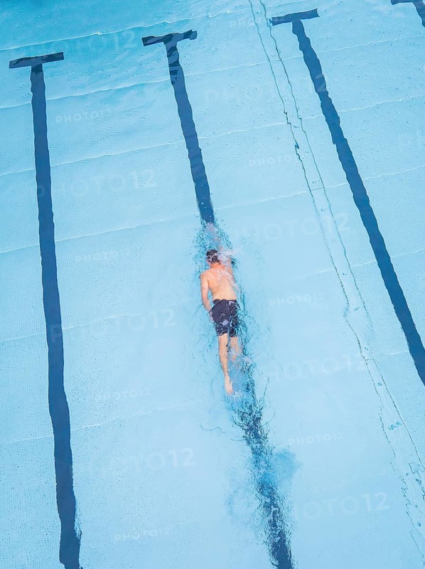A swimmer in a large pool, concentrating on swimming his laps, Calw outdoor pool, Black Forest, Germany