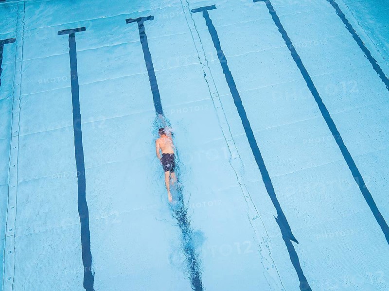 A single swimmer in the pool, calmly and steadily swimming his laps, Calw outdoor pool, Black Forest, Germany