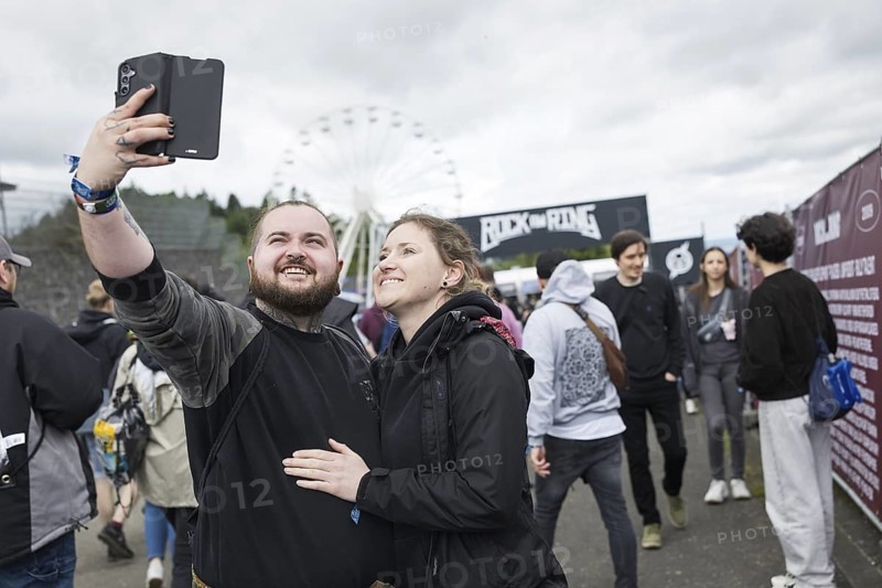 Festival visitors Kevin and Jenny take a photo in front of a container with the Rock am Ring logo at the Rock am Ring Festival on Friday, Nürburgring race track race track, 06.06.2025