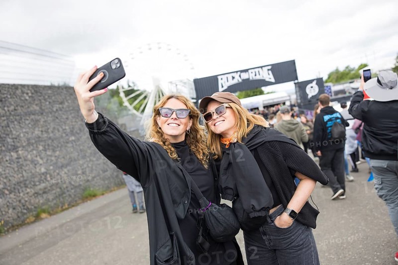 Two festival visitors take a photo of themselves in front of a container with the Rock am Ring logo at the Rock am Ring Festival on Friday, Nürburgring race track race track, 06.06.2025