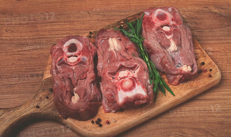 Raw steak, calf's neck on the bone, fresh meat, on the cutting board, top view, no people