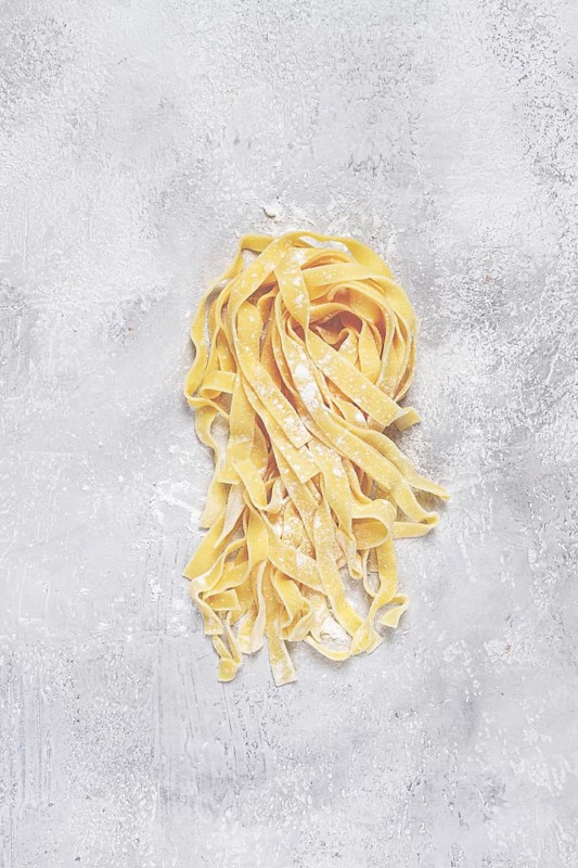 Raw tagliatelli pasta, homemade, top view, no people, rustic, food concept