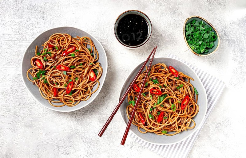 Udon noodles, with shimeji mushrooms, vegetables, in sauce, with sesame seeds, green onions, Asian vegetarian food, horizontal, without people