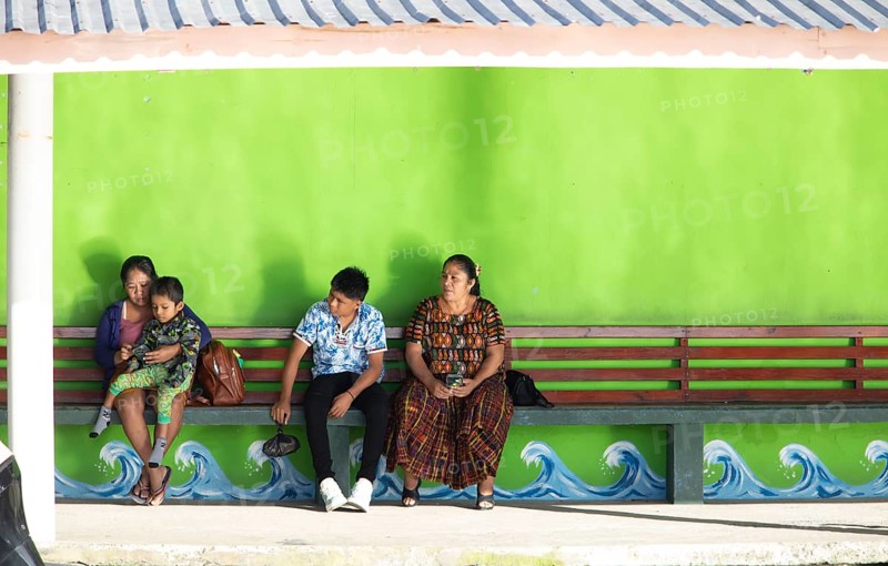 Guatemalans wait at the boat dock in Livingston on the Rio Dulce River, Izabal Department, Guatemala