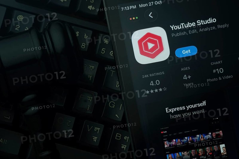 Dhaka, Bangladesh- 28 Oct 2025: An iPad displaying the Youtube Studio app against a judge's gavel and dark keyboard background