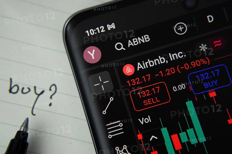 Dhaka, Bangladesh- 20 June 2025: Airbnb stock trading details displayed on smartphone with handwritten note