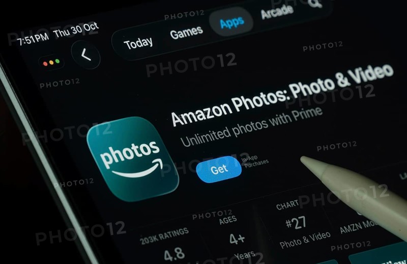 Dhaka, Bangladesh- 30 Oct 2025: Amazon photos app displayed on a iPad screen in dark mode with a digital pen pointing at it
