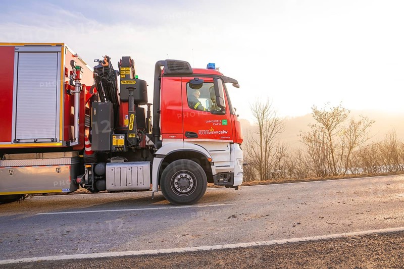 Fire engine on the road towards sunrise, landscape in the background, fire department exercise on the Hermann Hesse railway, Ostelsheim, Calw district, Germany
