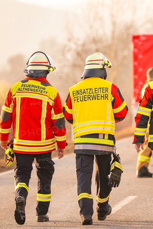 Firefighters walk together on a street, operational clothing and equipment visible, fire brigade exercise on the Hermann Hesse Railway, Ostelsheim, Calw district, Germany