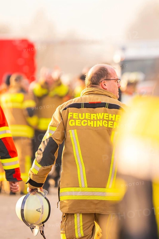 Firefighter with helmet in hand, blurred background activity, fire brigade exercise on the Hermann Hesse Railway, Ostelsheim, Calw district, Germany