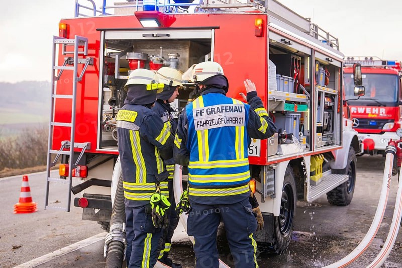 Firemen in emergency clothing stand at an emergency vehicle and check hoses, fire brigade exercise on the Hermann Hesse Railway, Ostelsheim, Calw district, Germany