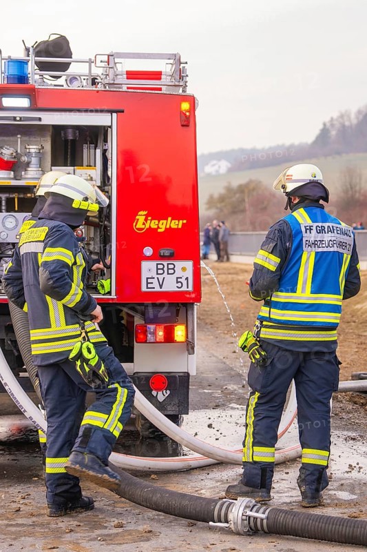 Firemen deployed next to a red fire truck. They wear helmets and special uniforms, fire department practice at the Hermann Hesse Railway, Ostelsheim, Calw district, Germany