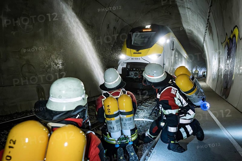 In the tunnel, a train of firefighters is sprayed with water. Respiratory equipment is worn, fire department exercise on the Hermann Hesse Railway, Ostelsheim, Germany