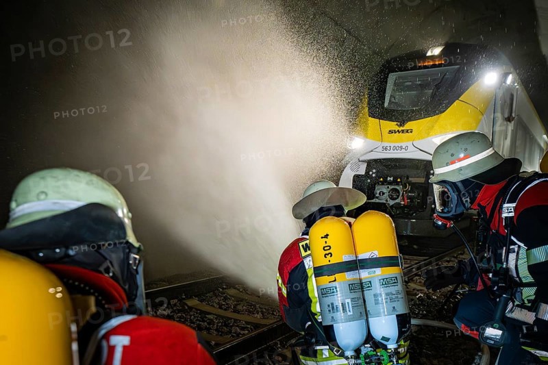 Firefighters spray a train in a tunnel with water. Respirators are used, fire department exercise on the Hermann Hesse railway, Ostelsheim, Germany
