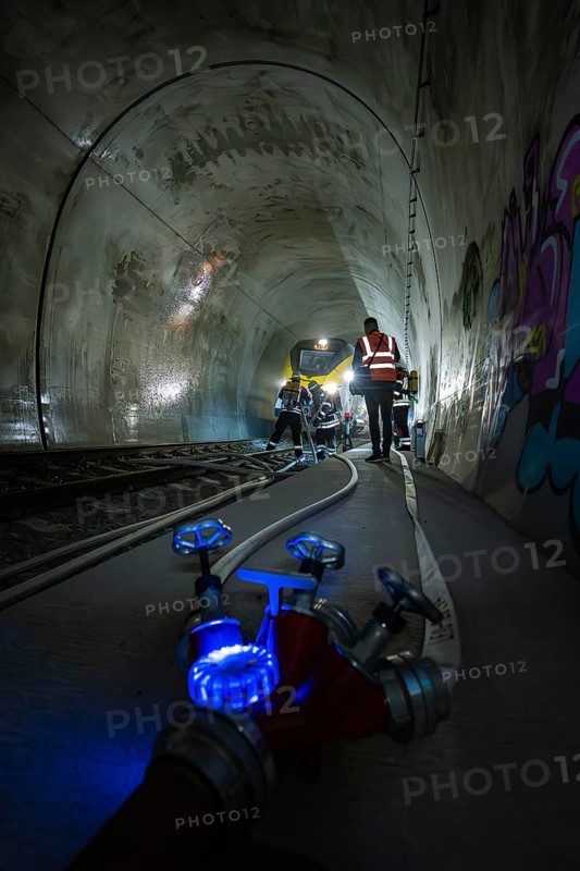 Workers in the dark railroad tunnel. Lighting and technical equipment are visible, fire department exercise on the Hermann Hesse Railway, Ostelsheim, Germany