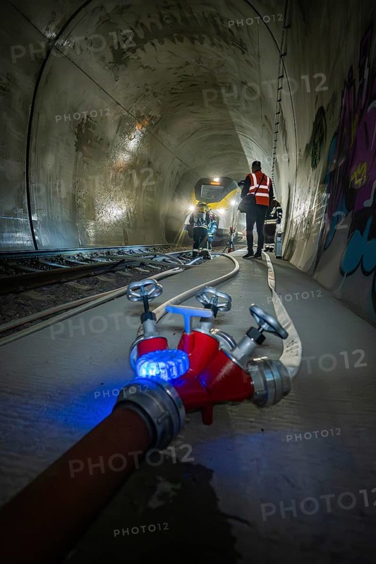 A water tap and fire hose in the foreground of a tunnel, fire brigade exercise on the Hermann Hesse Railway, Ostelsheim, Germany