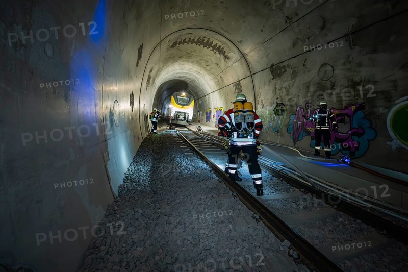 Firefighters working in an illuminated tunnel with graffiti, fire brigade exercise on the Hermann Hesse railway, Ostelsheim, Germany