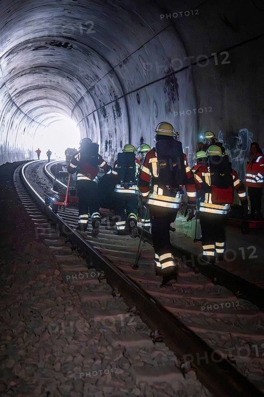 Firefighters in a tunnel focusing on darkness and equipment, fire department exercise on the Hermann Hesse railway, Ostelsheim, Germany