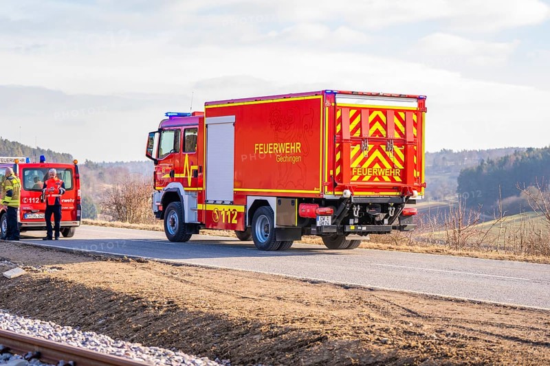 Red fire engine on a rural road in clear winter skies, fire department exercise on the Hermann Hesse railway, Ostelsheim, Germany