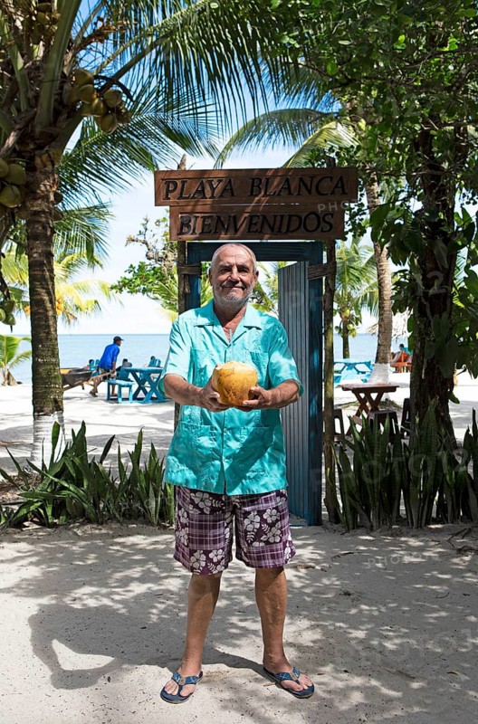 German manager, 67 years old, at Playa Blanca with a coconut, Izabal Department, Guatemala