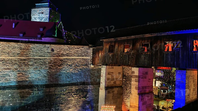 Historic bridge and castle structure, colourfully illuminated at night, Kronach glows, Franconian Forest nature park Park
