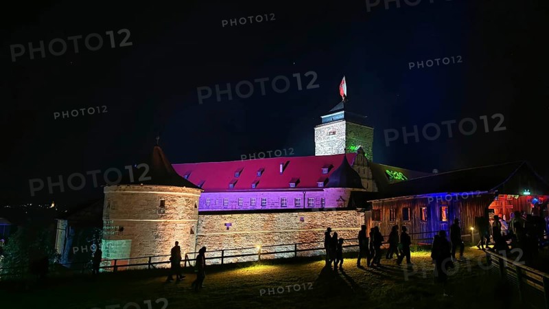 Illuminated castle at night with visitors and colorful lighting, Kronach glows, Frankenwald nature park Park