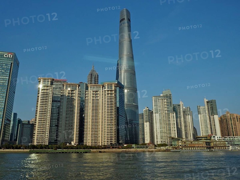 City skyline of Huangpu Jiang with tall modern buildings against blue sky on the water, Pudong, Shanghai, China