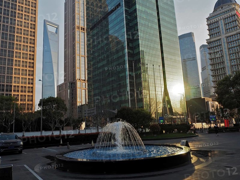 Skyscrapers with reflective glass facades and a fountain in the city center, Pudong, Shanghai, China