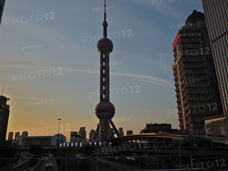 Oriental Pearl Tower in an urban skyline at sunset with skyscrapers in the background, Shanghai, China