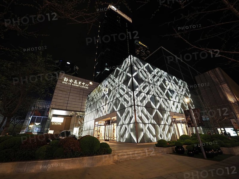 Modern building, Jing An Kerry Centre, at night with illuminated façade in an urban setting, Shanghai, China