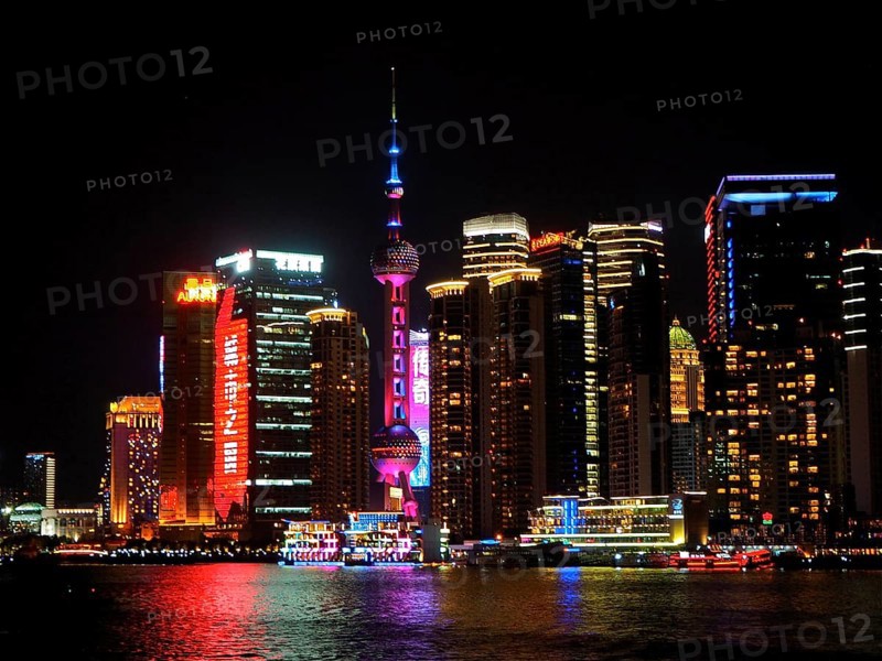 Illuminated skyline with the iconic Oriental Pearl Tower shining in the light at night, Shanghai, China