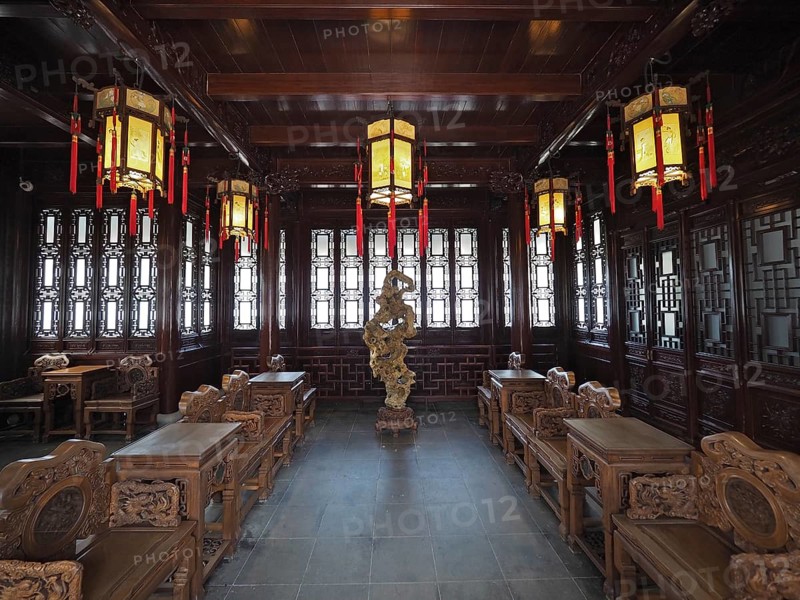 An elegant interior design with Asian lanterns, wood decor, and ornate furniture in warm tones, Yuyuan Garden, Shanghai, China