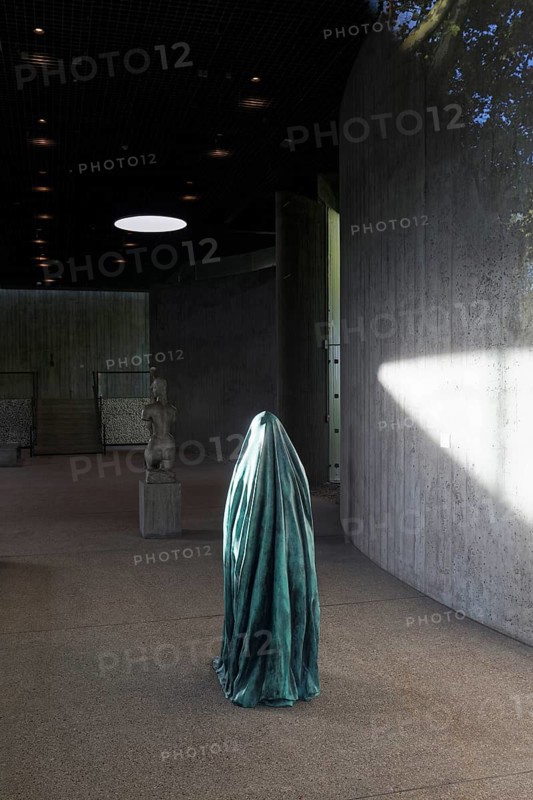 Statue of a veiled figure in the Lehmbruck Museum, looking through window, self-portrait as a ghost by sculptor Alicja Kwade, Duisburg, North Rhine-Westphalia, Germany
