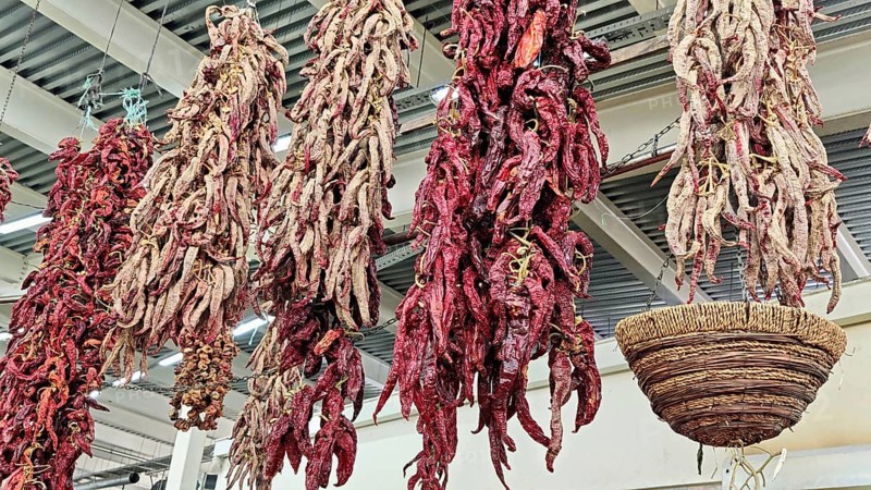 Dried chilli peppers (capsicum annuum) hanging next to a woven basket, Skopje, North Macedonia