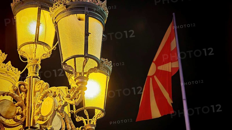 Night view of an illuminated lantern and a North Macedonia flag in the dark, Skopje, North Macedonia