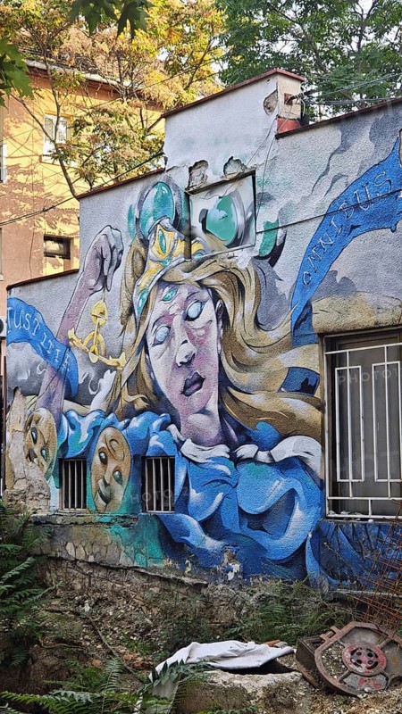 Wall art of a mythical woman surrounded by vivid colors and details, Pristina, Kosovo