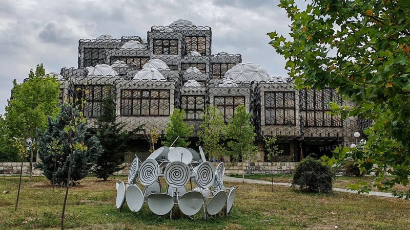 Architecturally distinctive building with domes and surrounding nature, National Library, Pristina, Kosovo