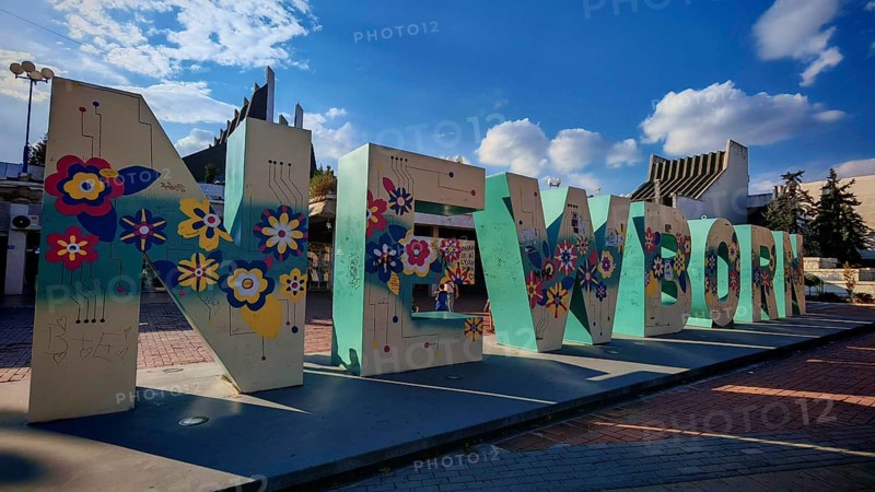 Large letter sculpture, newborn, with floral motifs against a blue sky, Pristina, Kosovo