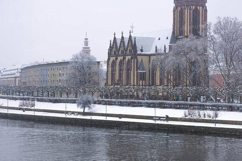 A passerby walks along the banks of the Main with an umbrella. Heavy snowfalls have caused another onset of winter in the Main metropolis, Osthafen, Frankfurt am Main, Hesse, Germany