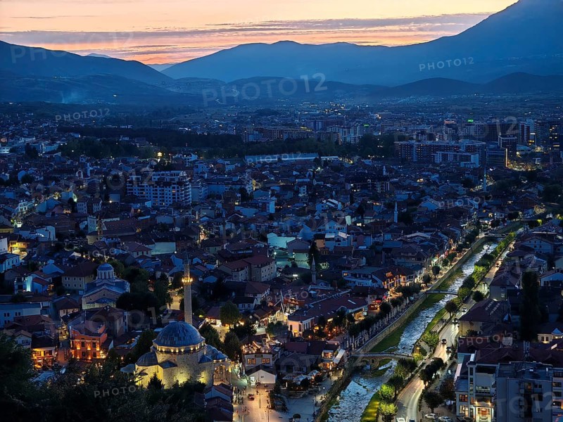 Night scene of an illuminated city with river and mountains in the background, Prizren, Kosovo
