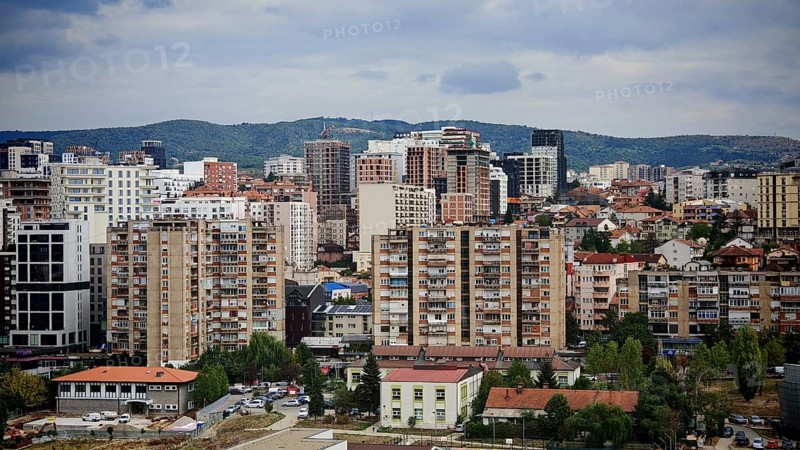 Dense urban landscape with skyscrapers and mountains in the background, Pristina, Kosovo