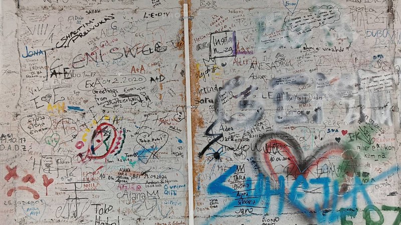 Wall full of colorful graffiti and doodles separating two different sections, Pristina, Kosovo