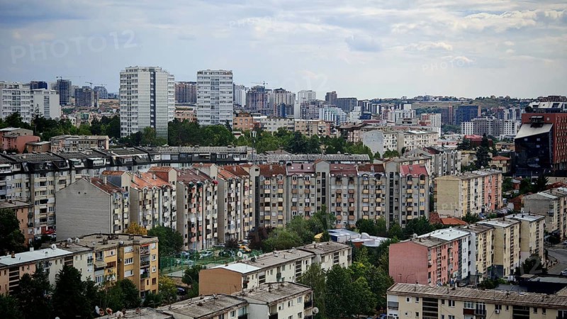 View of a city with numerous residential buildings under a slightly cloudy sky, Pristina, Kosovo