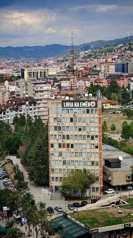 Skyscraper with signs in the city center under a cloudy sky, Pristina, Kosovo