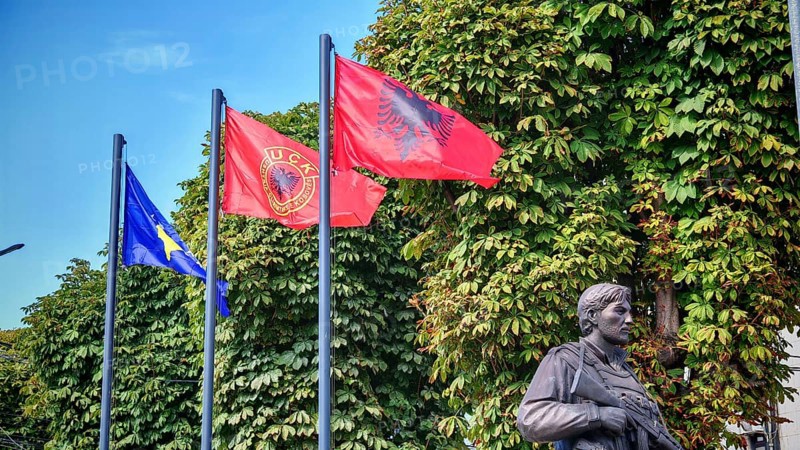 Memorial with flags of Kosovo, Albania and KLA against green background, Prizren, Kosovo